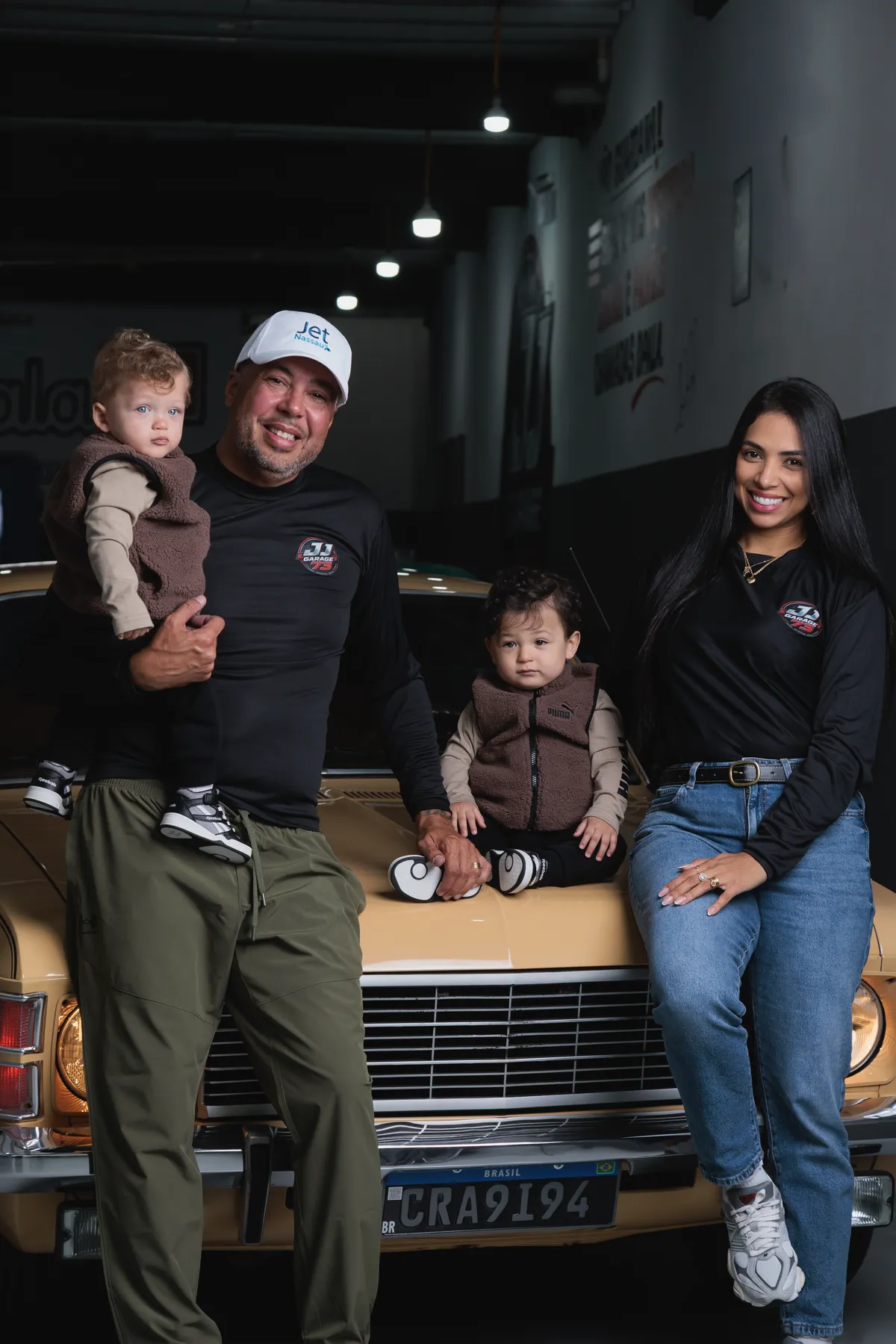 Família reunida em volta do Opala cupê dourado na garagem